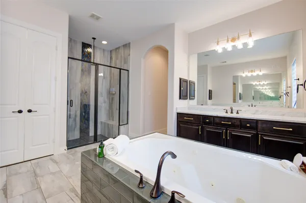 a spacious bathroom with a tub sink and mirror