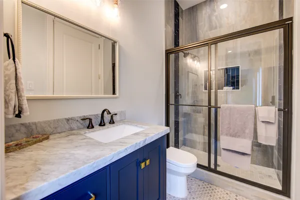 a bathroom with a granite countertop sink toilet and shower