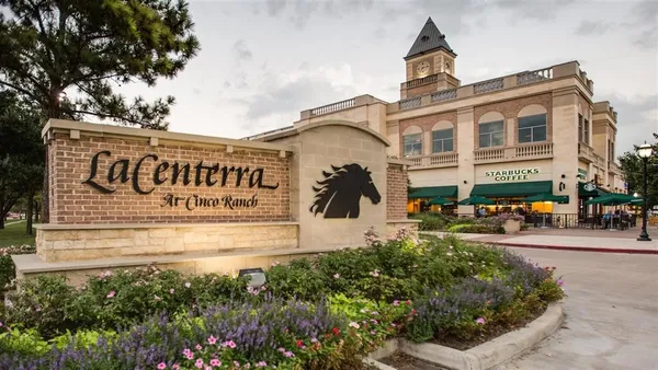 a front view of a building with garden and seating area