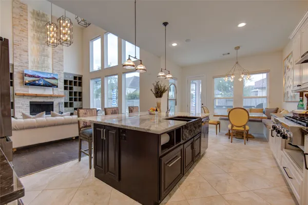 a kitchen with stainless steel appliances granite countertop a stove and a view of living room
