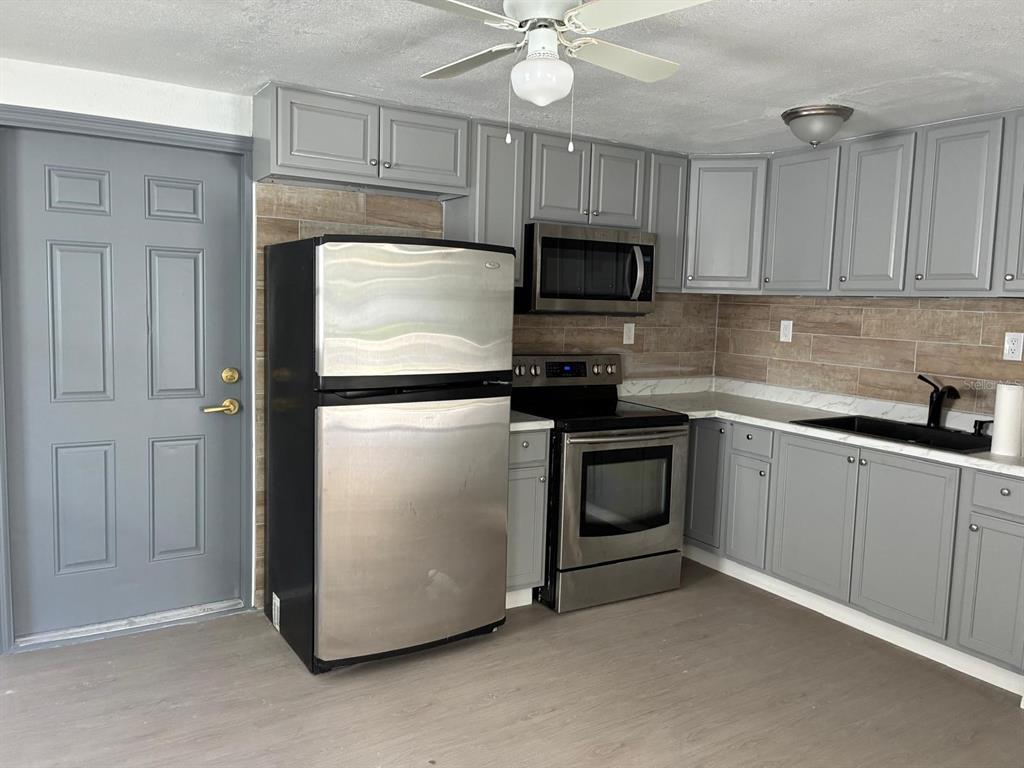 1008 Nebraska Street Leesburg, FL 34748 - Photo 5 of 26 a kitchen with granite countertop white cabinets and stainless steel appliances