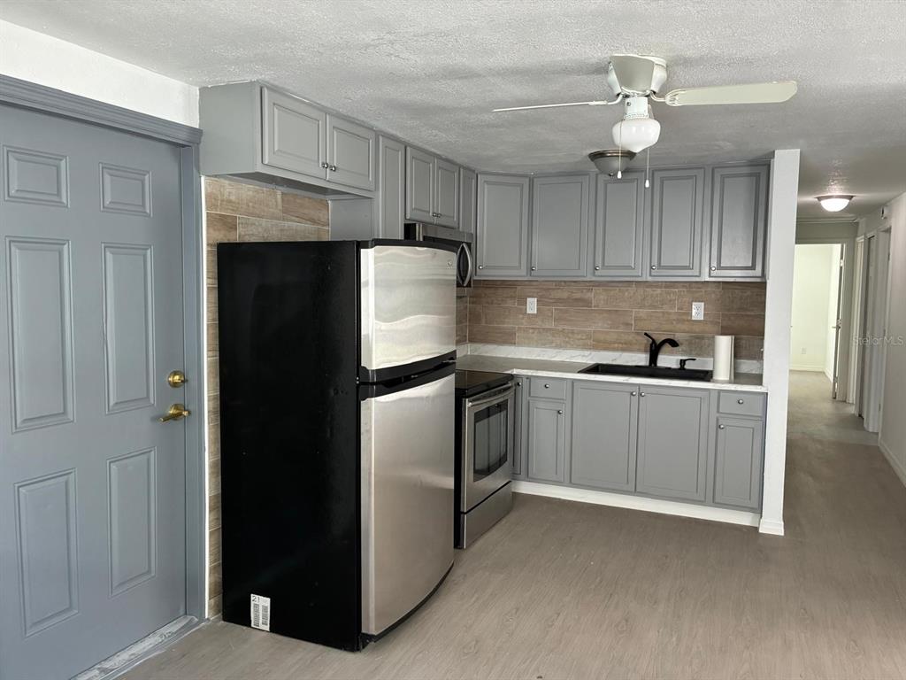 1008 Nebraska Street Leesburg, FL 34748 - Photo 6 of 26 a kitchen with a refrigerator sink and cabinets