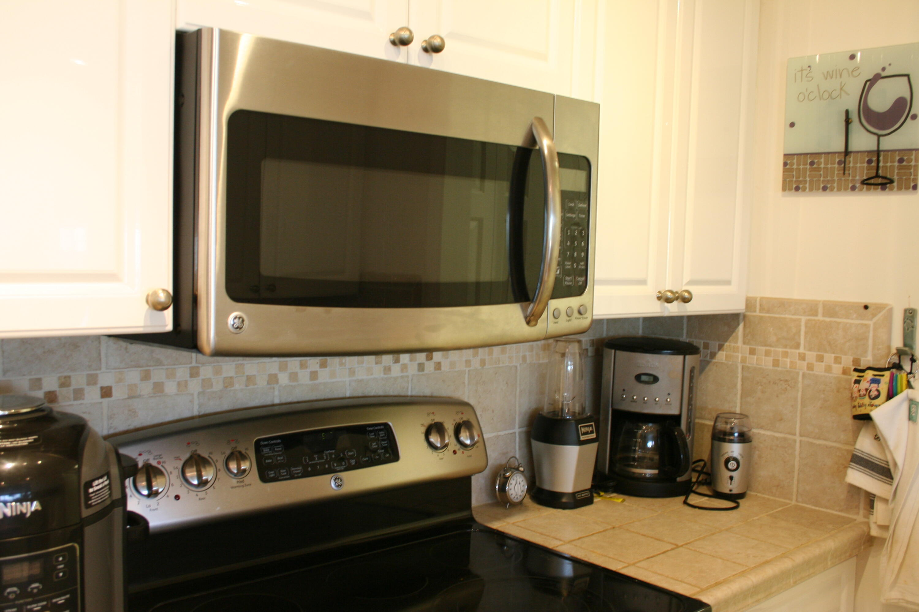 104500 Overseas Highway, Unit A302 Key Largo, FL 33037 - Photo 3 of 35 a kitchen with a stove and a microwave