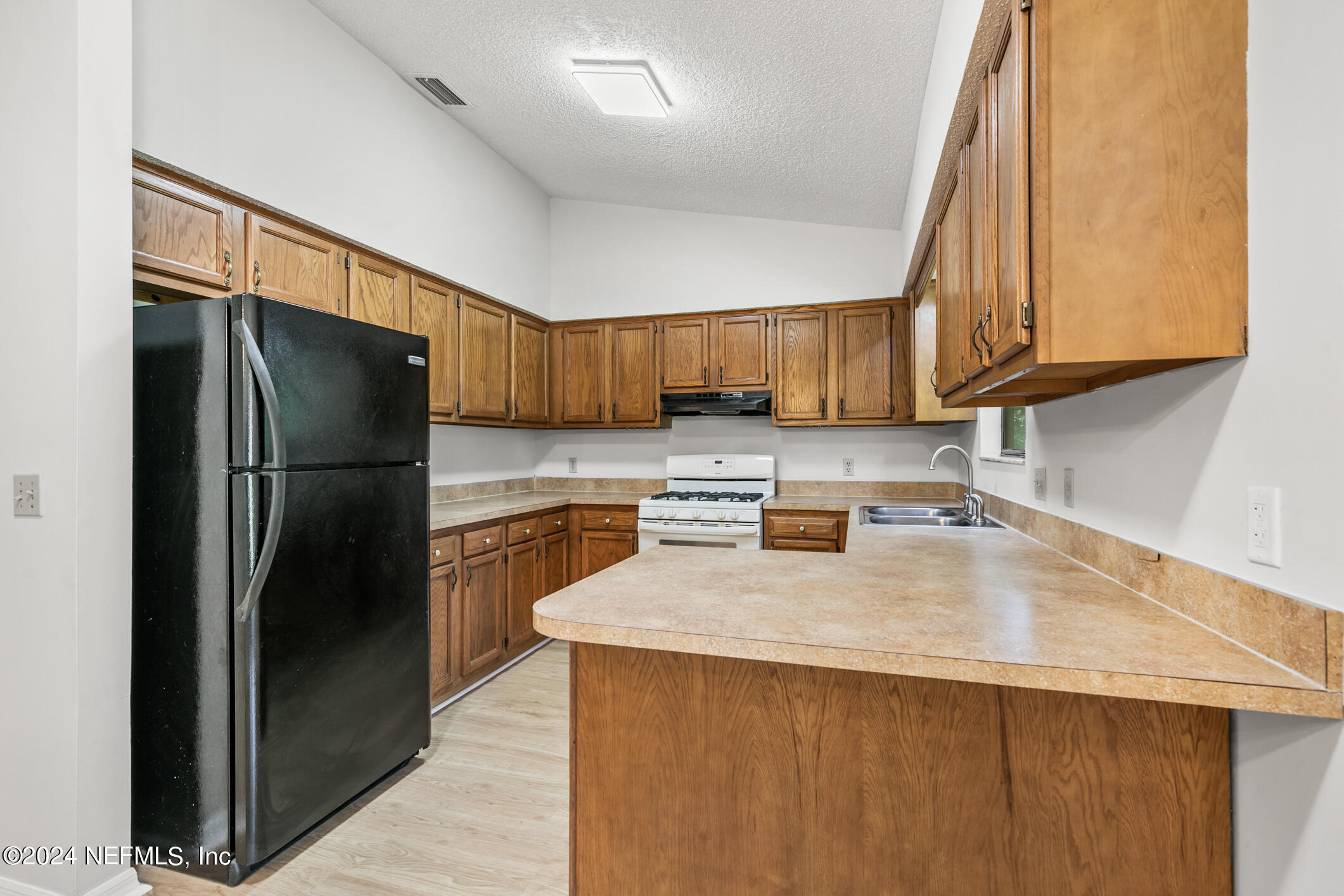 5165 Datil Pepper Road St. Augustine, FL 32086 - Photo 21 of 54 a kitchen with granite countertop a refrigerator and a sink