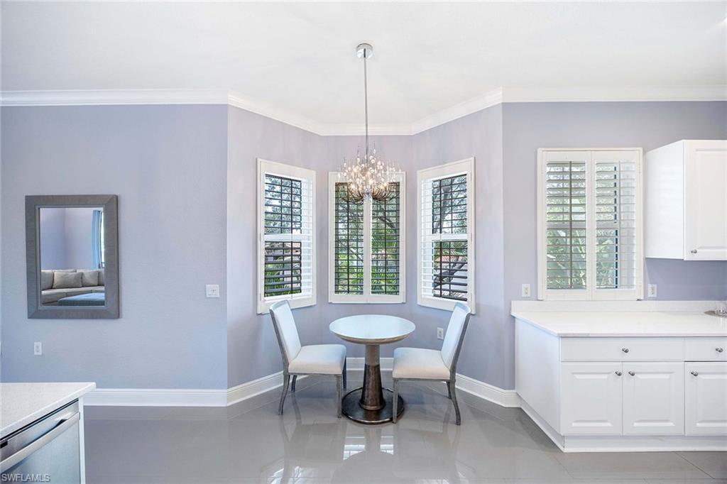 9202 Museo Circle, Unit 204 Naples, FL 34114 - Photo 16 of 37 a view of a dining room with furniture a chandelier and wooden floor
