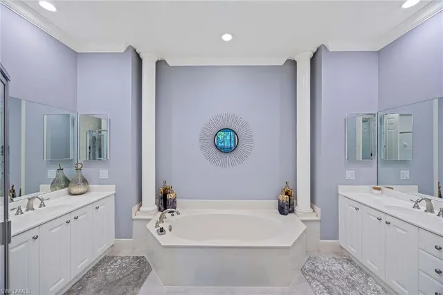 a bathroom with a white tub shower vanity and a sink