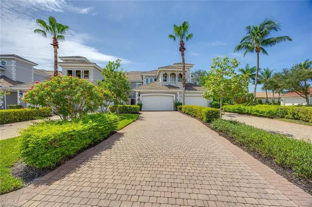 a front view of a house with a yard and potted plants