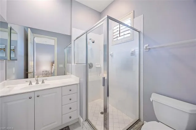 a bathroom with a double vanity sink toilet mirror and shower