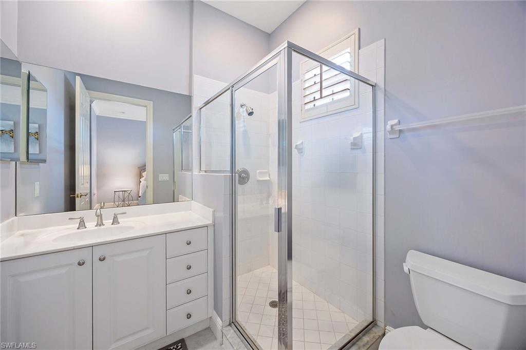 9202 Museo Circle, Unit 204 Naples, FL 34114 - Photo 30 of 37 a bathroom with a double vanity sink toilet mirror and shower