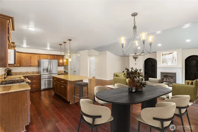 a dining room with wooden floor a chandelier a wooden table and chairs
