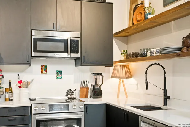 a kitchen with stainless steel appliances granite countertop a stove and a microwave