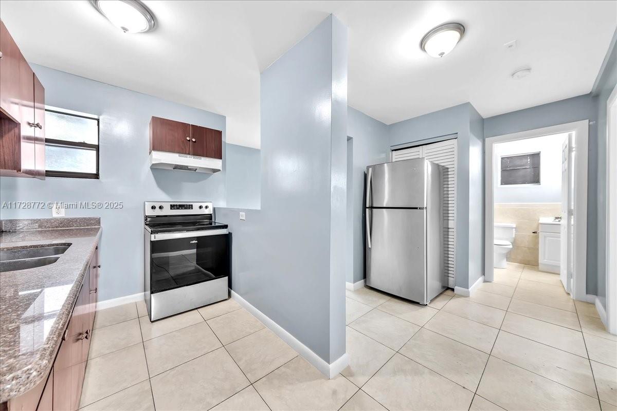 365 Northwest 8th Street, Unit 211 Miami, FL 33136 - Photo 1 of 29 a kitchen with stainless steel appliances a refrigerator and a stove top oven