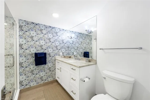 a bathroom with a granite countertop sink toilet and shower