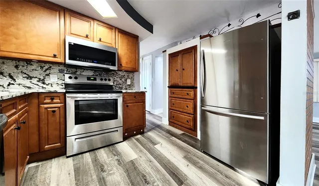 a kitchen with stainless steel appliances a refrigerator stove and microwave