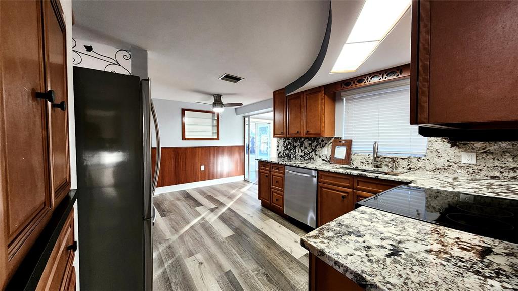 3629 Bedford Street New Port Richey, FL 34652 - Photo 10 of 29 a kitchen with stainless steel appliances kitchen island granite countertop wooden floor a refrigerator and a stove