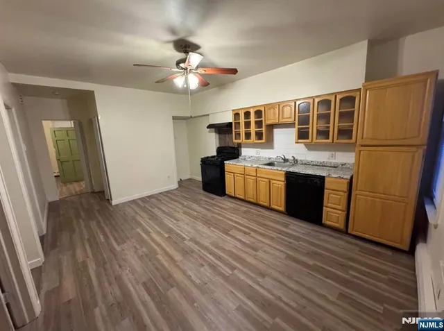 a view of kitchen with granite countertop cabinets and refrigerator