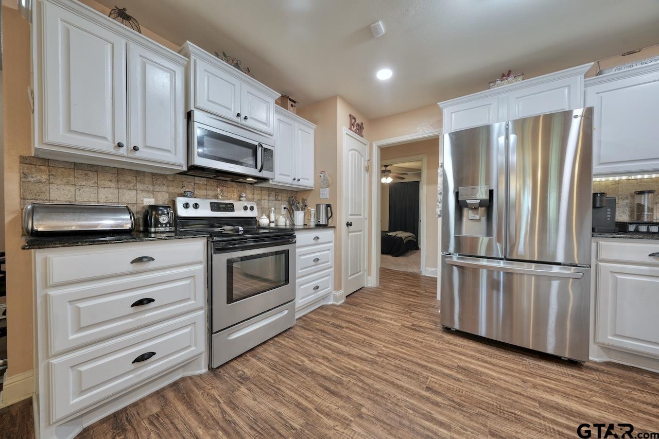 412 Elm Lane Lindale, TX 75771 - Photo 16 of 48 a kitchen with stainless steel appliances a refrigerator stove and white cabinets