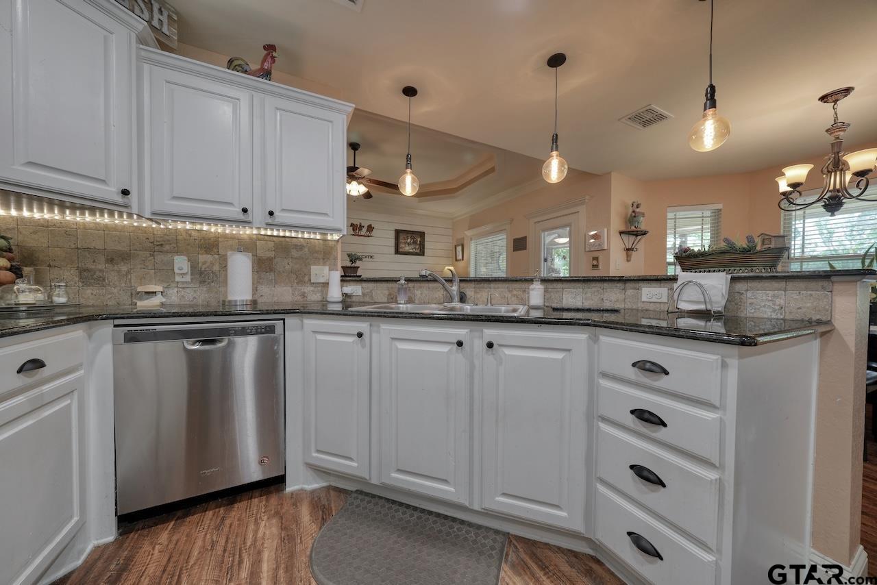 412 Elm Lane Lindale, TX 75771 - Photo 19 of 48 a kitchen with kitchen island granite countertop a sink cabinets and stainless steel appliances