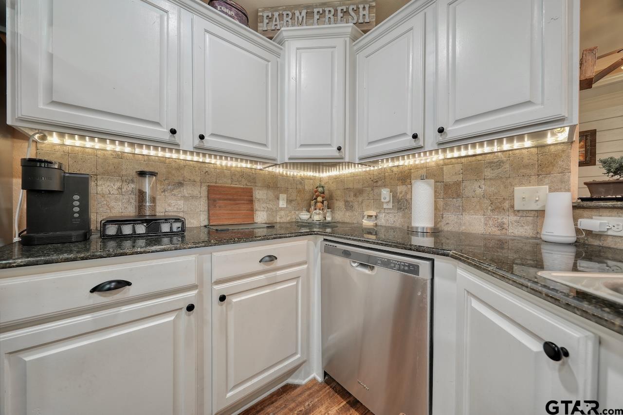 412 Elm Lane Lindale, TX 75771 - Photo 20 of 48 a kitchen with granite countertop white cabinets and white appliances