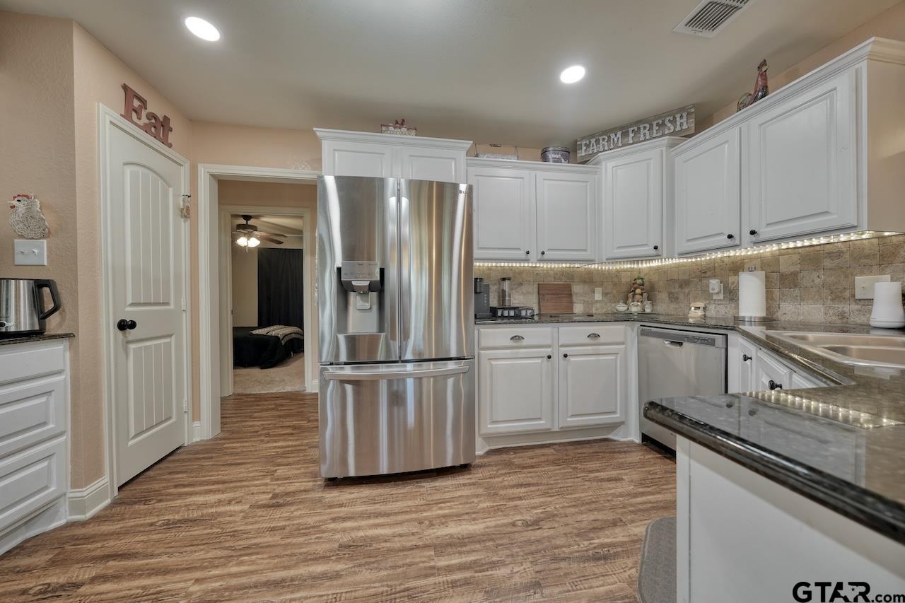 412 Elm Lane Lindale, TX 75771 - Photo 21 of 48 a kitchen with white cabinets and stainless steel appliances