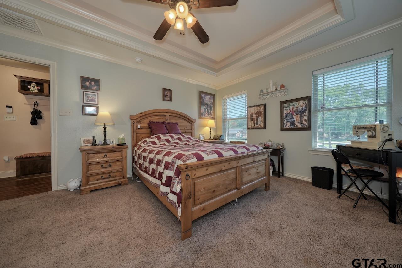 412 Elm Lane Lindale, TX 75771 - Photo 24 of 48 a bedroom with a bed and a chandelier
