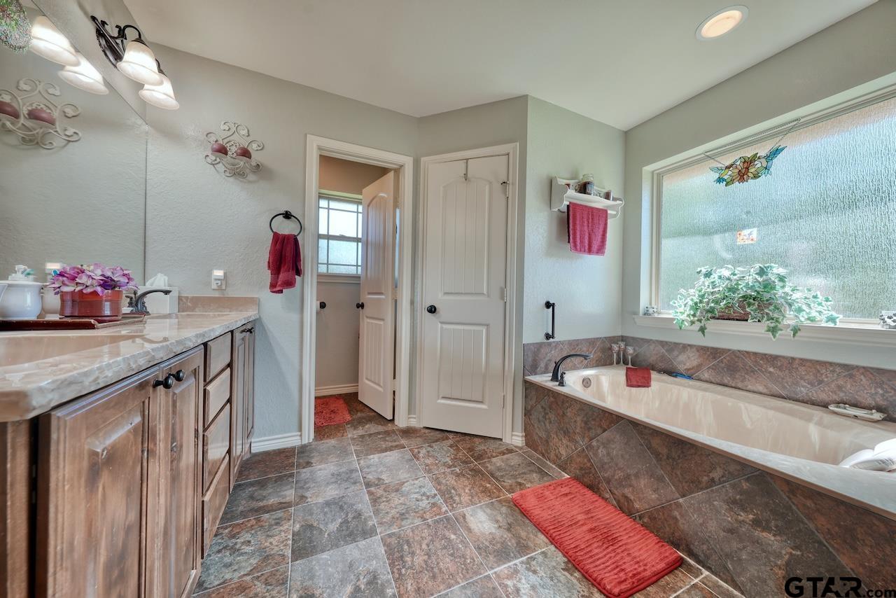 412 Elm Lane Lindale, TX 75771 - Photo 26 of 48 a spacious bathroom with a tub sink and mirror