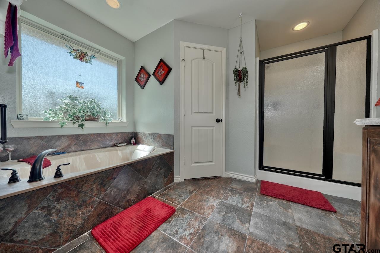412 Elm Lane Lindale, TX 75771 - Photo 28 of 48 a spacious bathroom with a tub sink and mirror