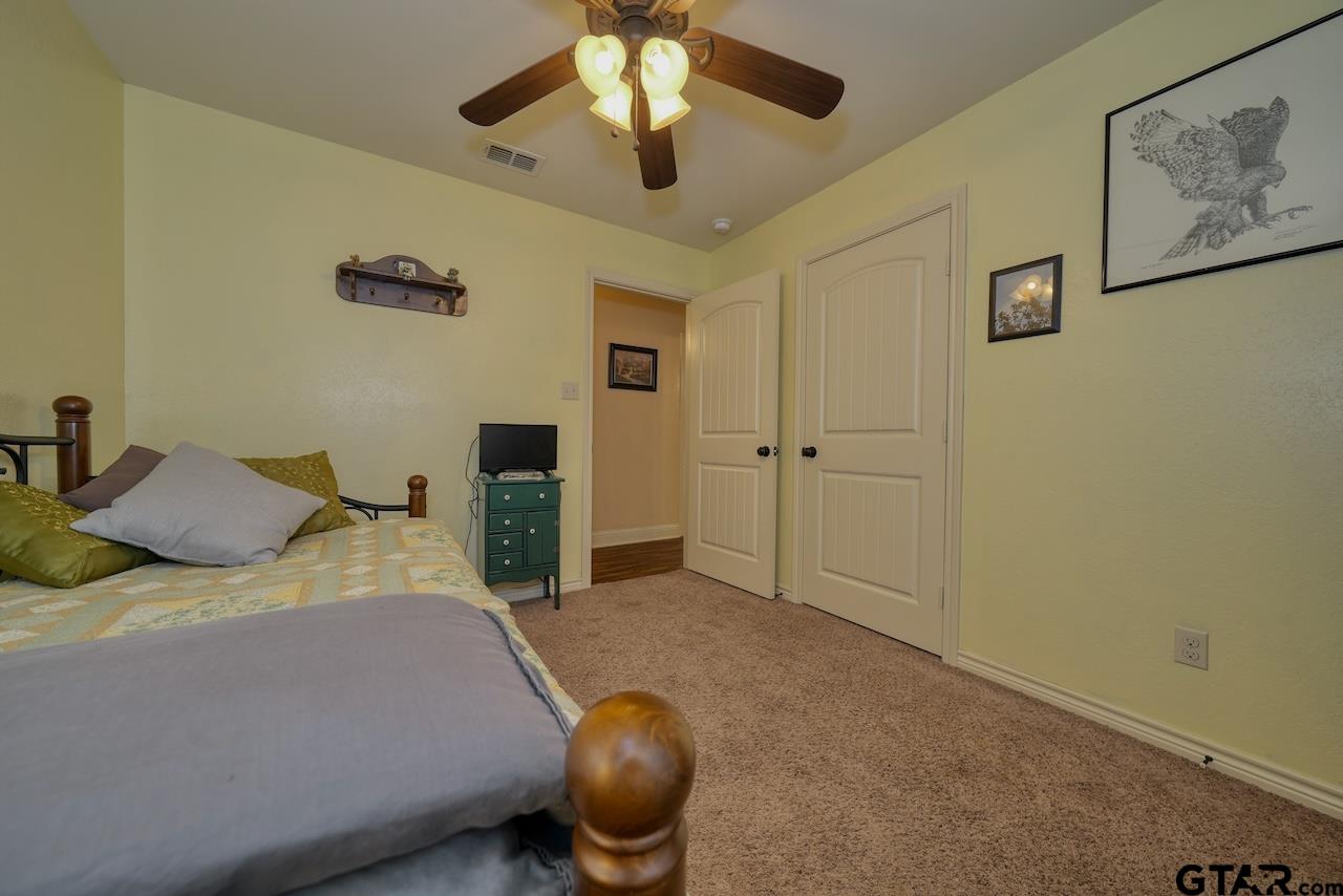 412 Elm Lane Lindale, TX 75771 - Photo 31 of 48 a bedroom with a bed and a chandelier