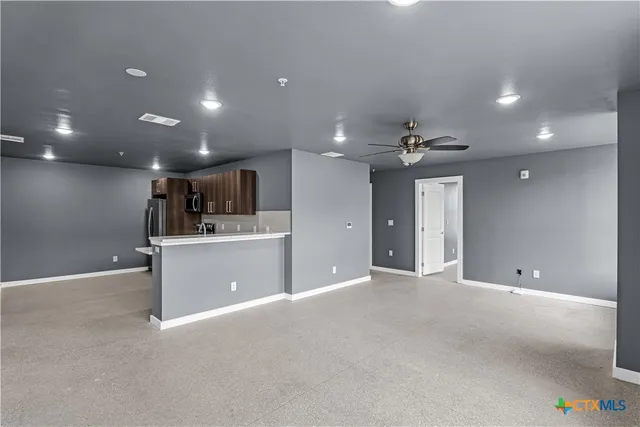 a view of an empty room with a kitchen
