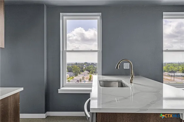 a view of a kitchen with a sink and a large window