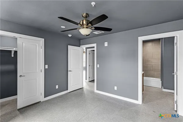 a view of an empty room with a ceiling fan
