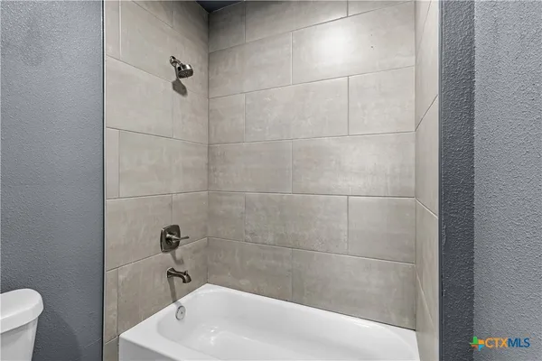 a bath tub sitting next to a white toilet