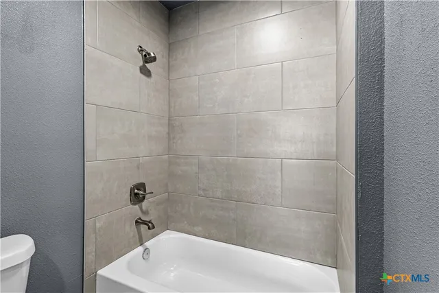 a bath tub sitting next to a white toilet