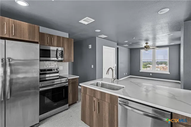 a kitchen with a sink stainless steel appliances and cabinets