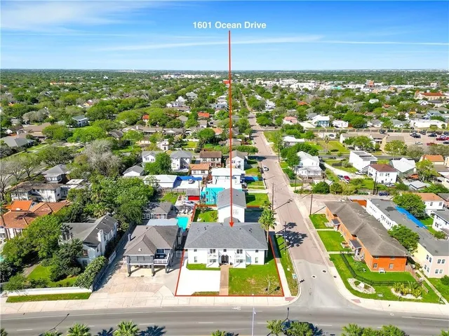 an aerial view of residential houses with outdoor space and street view