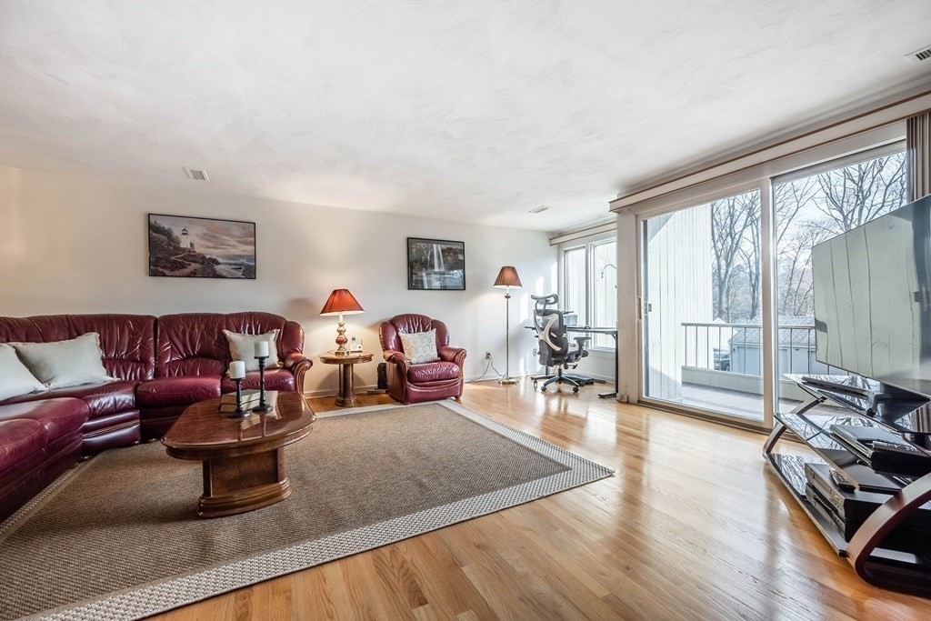 101 Mill Pond, Unit 101 North Andover, MA 01845 - Photo 11 of 27 a living room with furniture large window and wooden floor