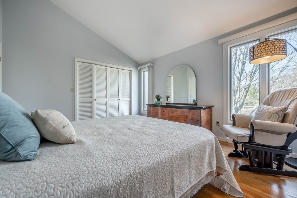 101 Mill Pond, Unit 101 North Andover, MA 01845 - Photo 19 of 27 a spacious bedroom with a bed a couch and a dresser next to a window