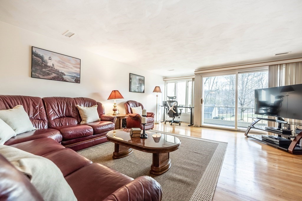 101 Mill Pond, Unit 101 North Andover, MA 01845 - Photo 10 of 27 a living room with furniture a flat screen tv and a large window