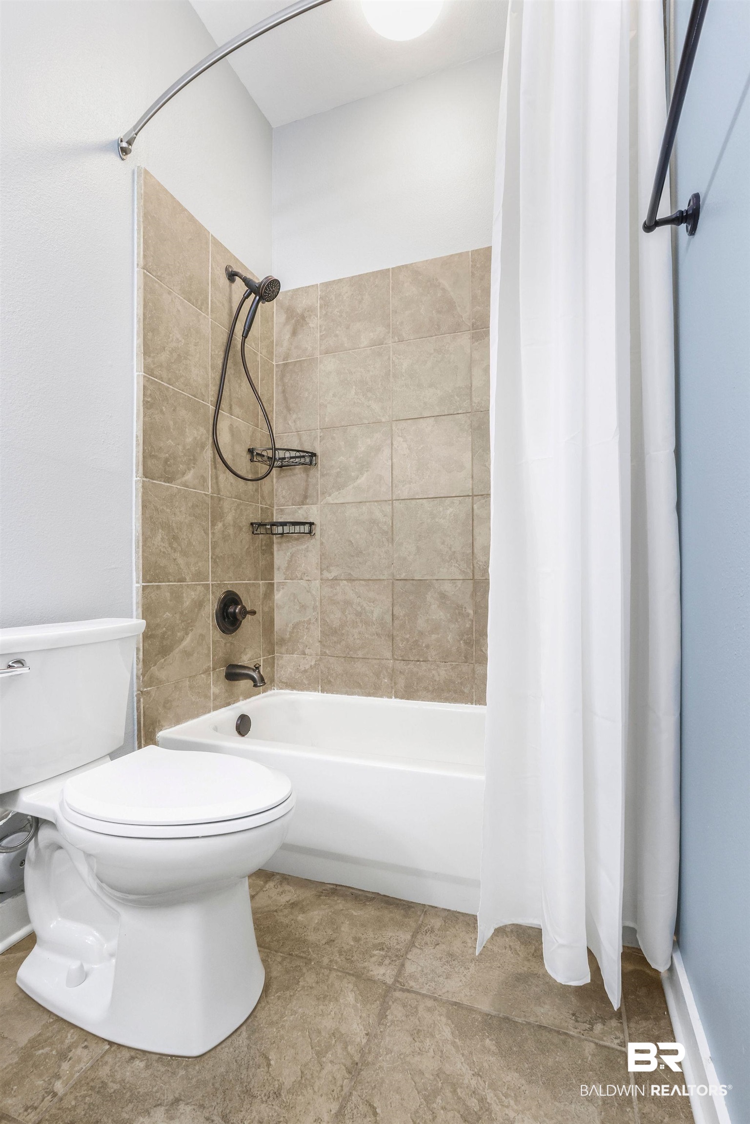 1430 Regency Road, Unit B302 Gulf Shores, AL 36542 - Photo 16 of 24 Bathroom featuring tile patterned floors, shower / bath combination with curtain, and toilet