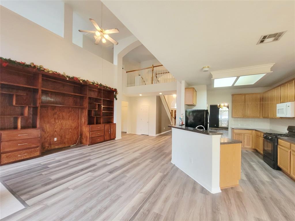 6708 Kilt Court Austin, TX 78754 - Photo 11 of 32 a large kitchen with kitchen island a stove a refrigerator a sink dishwasher with a dining table and chairs with wooden floor