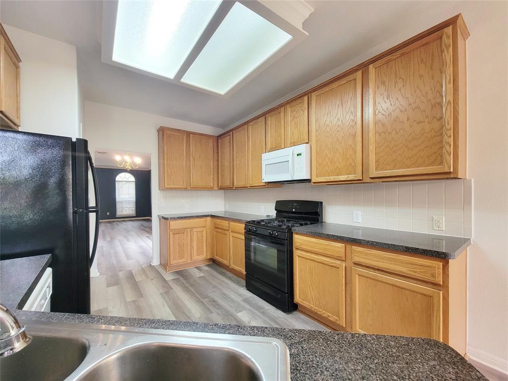 6708 Kilt Court Austin, TX 78754 - Photo 12 of 32 a kitchen with stainless steel appliances granite countertop a refrigerator a stove and a sink with cabinets