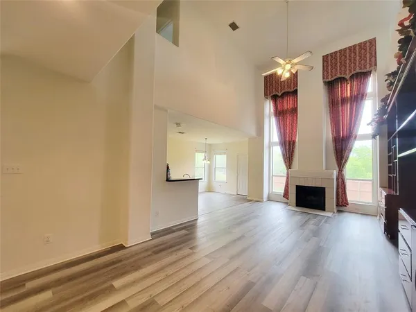 a view of a livingroom with wooden floor fireplace and window