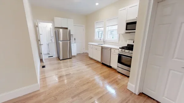 a kitchen with white cabinets and stainless steel appliances