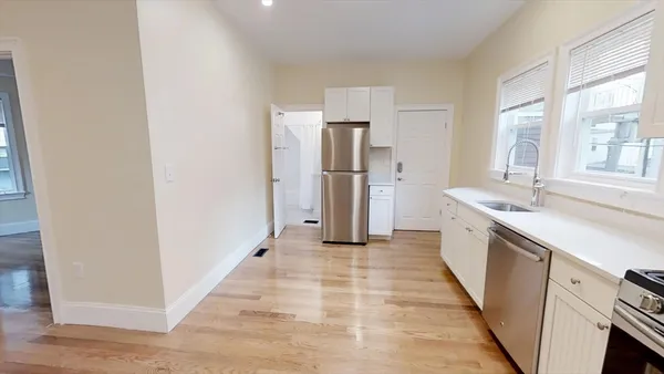 a large white kitchen with white cabinets and stainless steel appliances