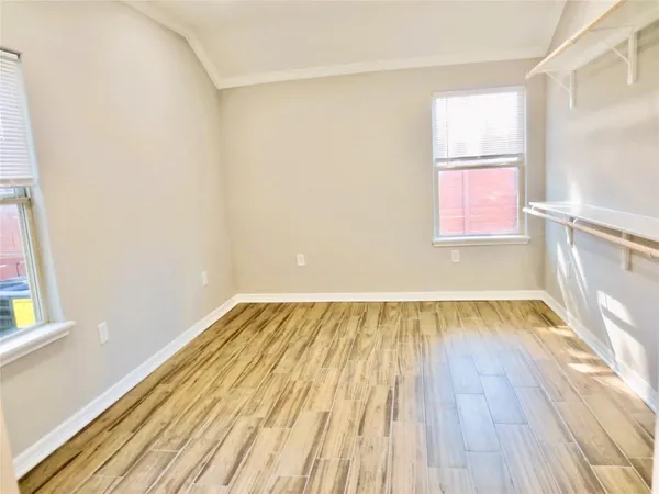 a view of a room with wooden floor and small window