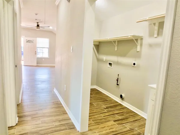 a view of a hallway with wooden floor and staircase