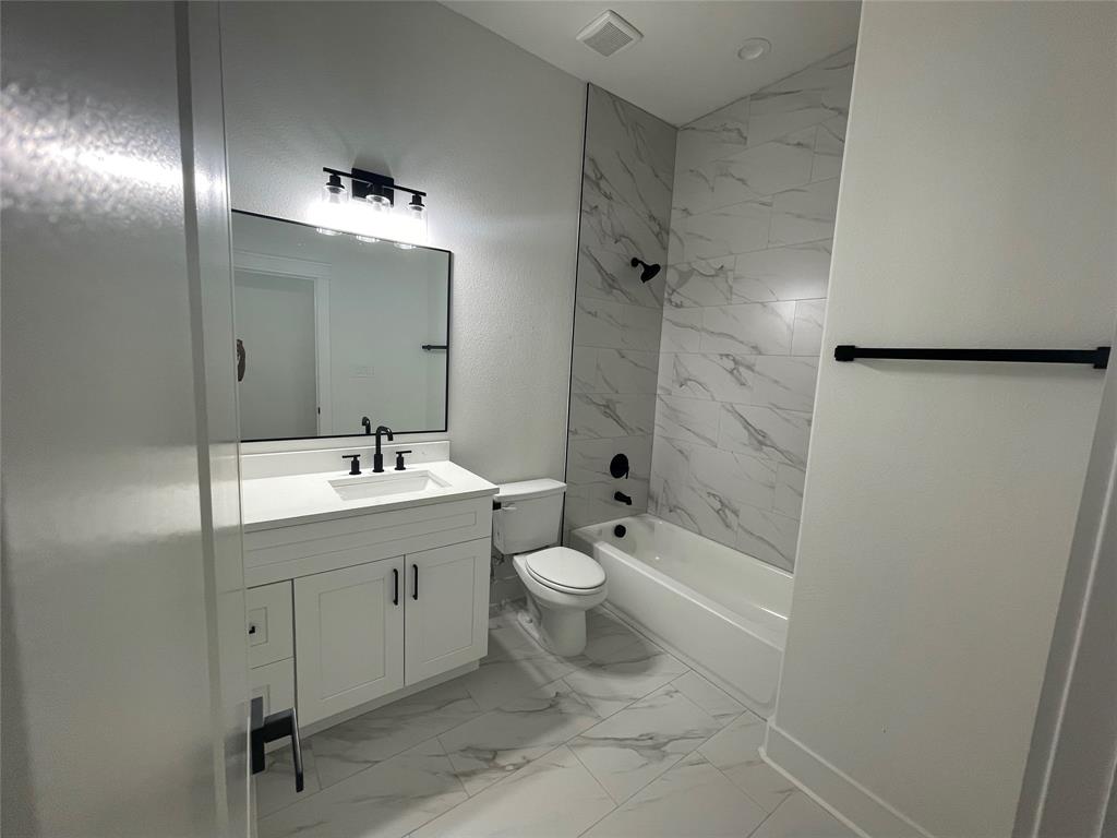 3535 Spring Avenue Dallas, TX 75210 - Photo 11 of 19 Bathroom featuring vanity, light marble finish floors, and shower / bath combination