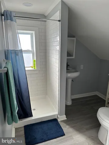 a bathroom with a sink a toilet a window and vanity