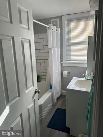 a bathroom with sink shower and a mirror
