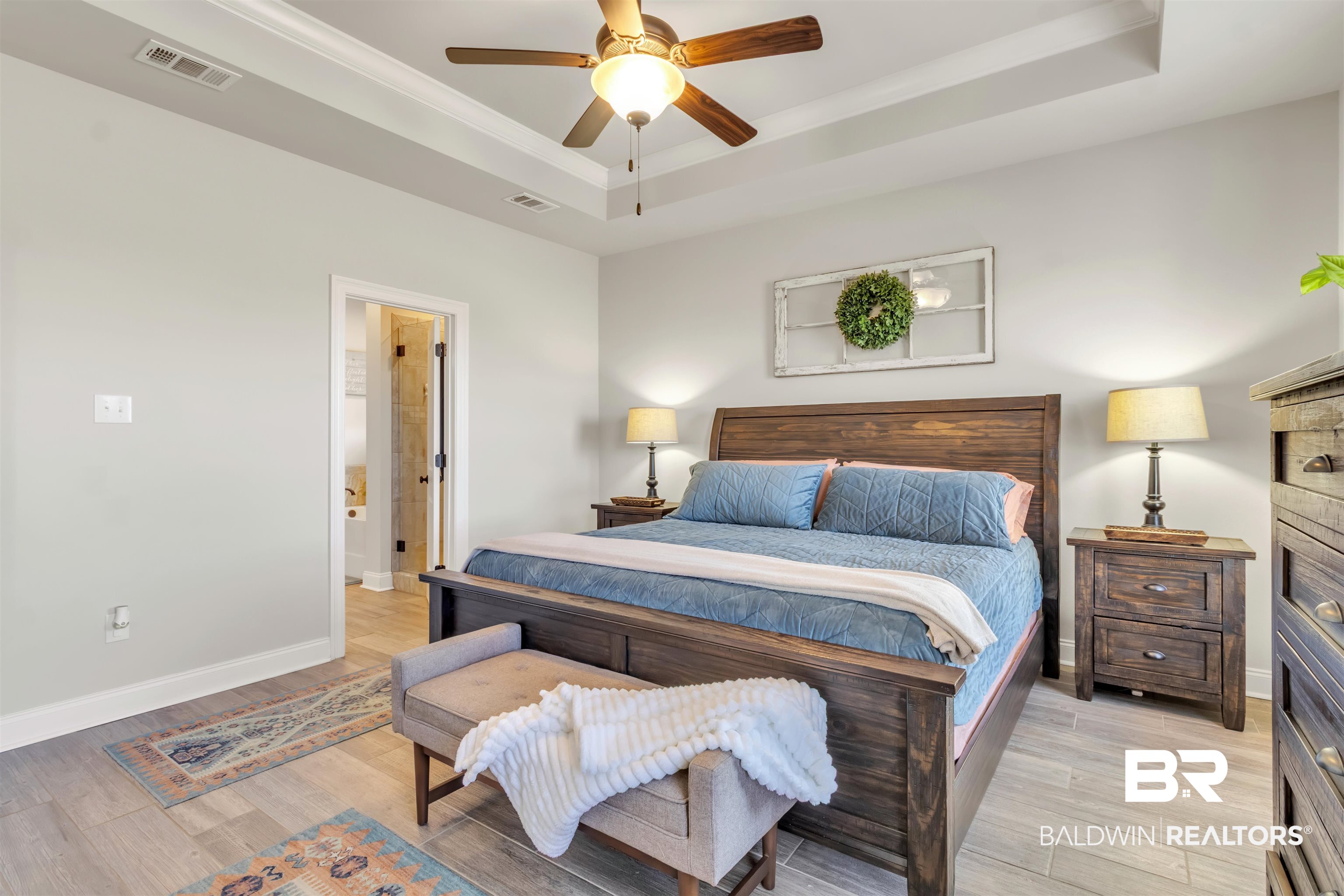 22531 Putter Lane Foley, AL 36535 - Photo 21 of 43 Bedroom with a raised ceiling, light wood-style floors, ceiling fan, ensuite bath, and crown molding